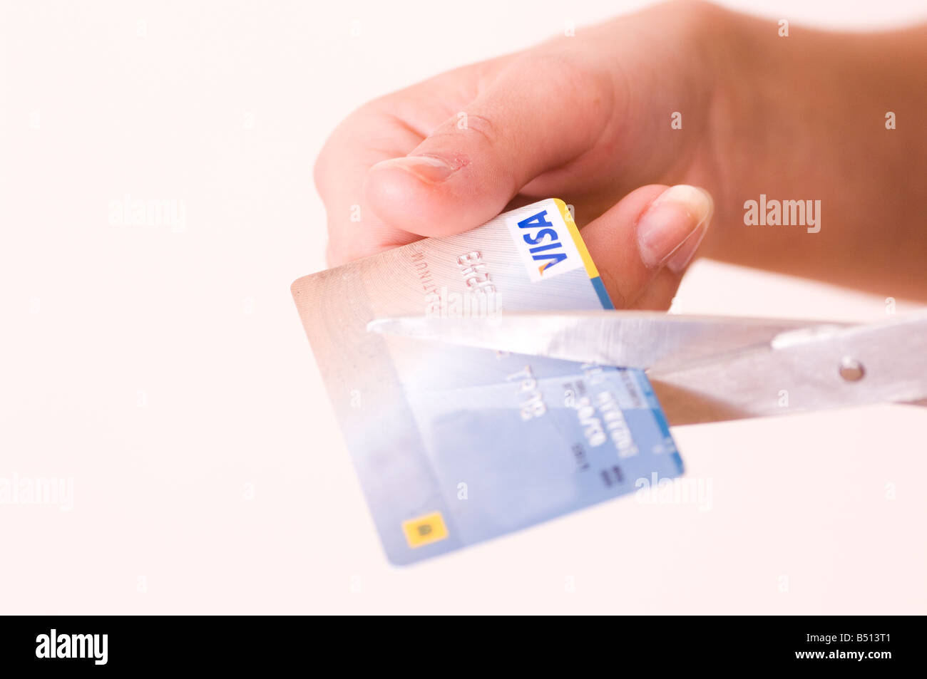 Mani il taglio di carta di credito con le forbici Foto Stock