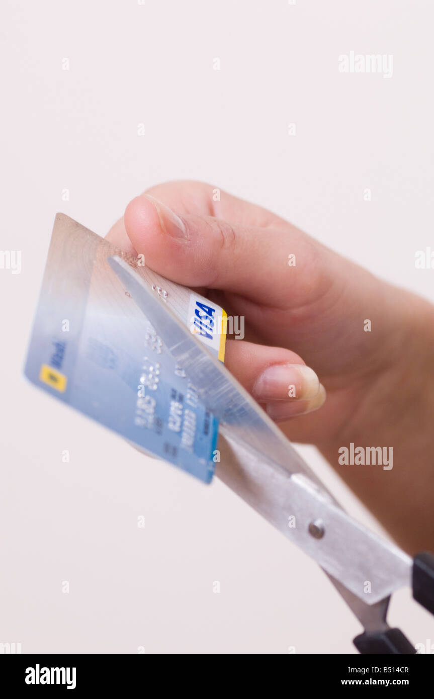 Mani il taglio di carta di credito con le forbici Foto Stock