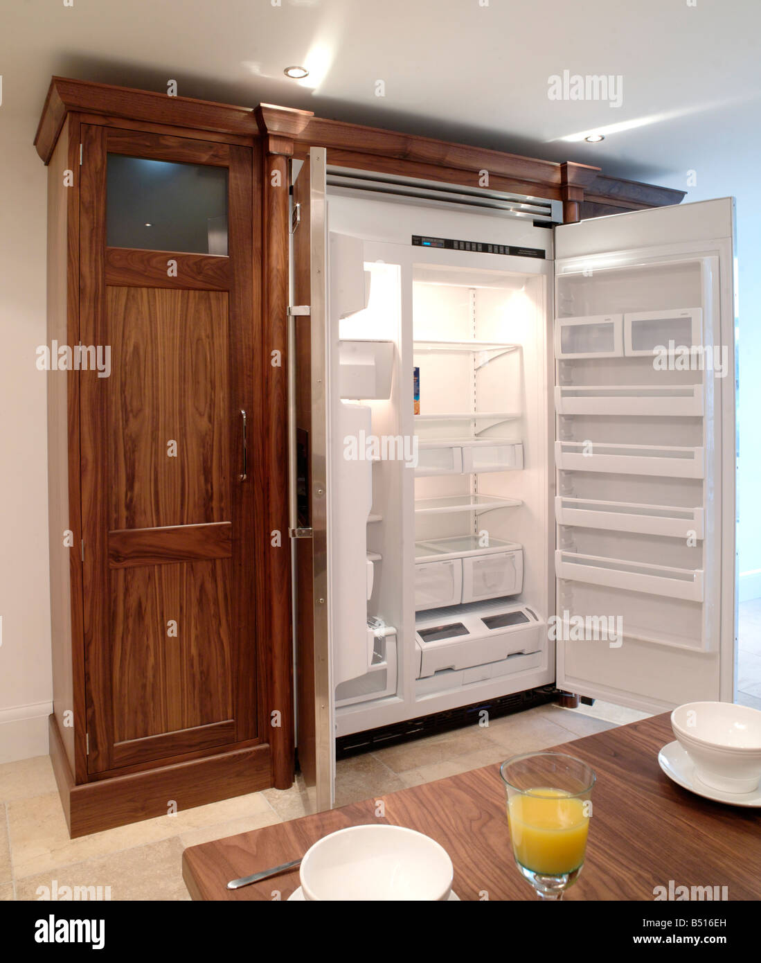 Free standing frigo congelatore con enclosure di storage e rifinito in legno scuro Foto Stock