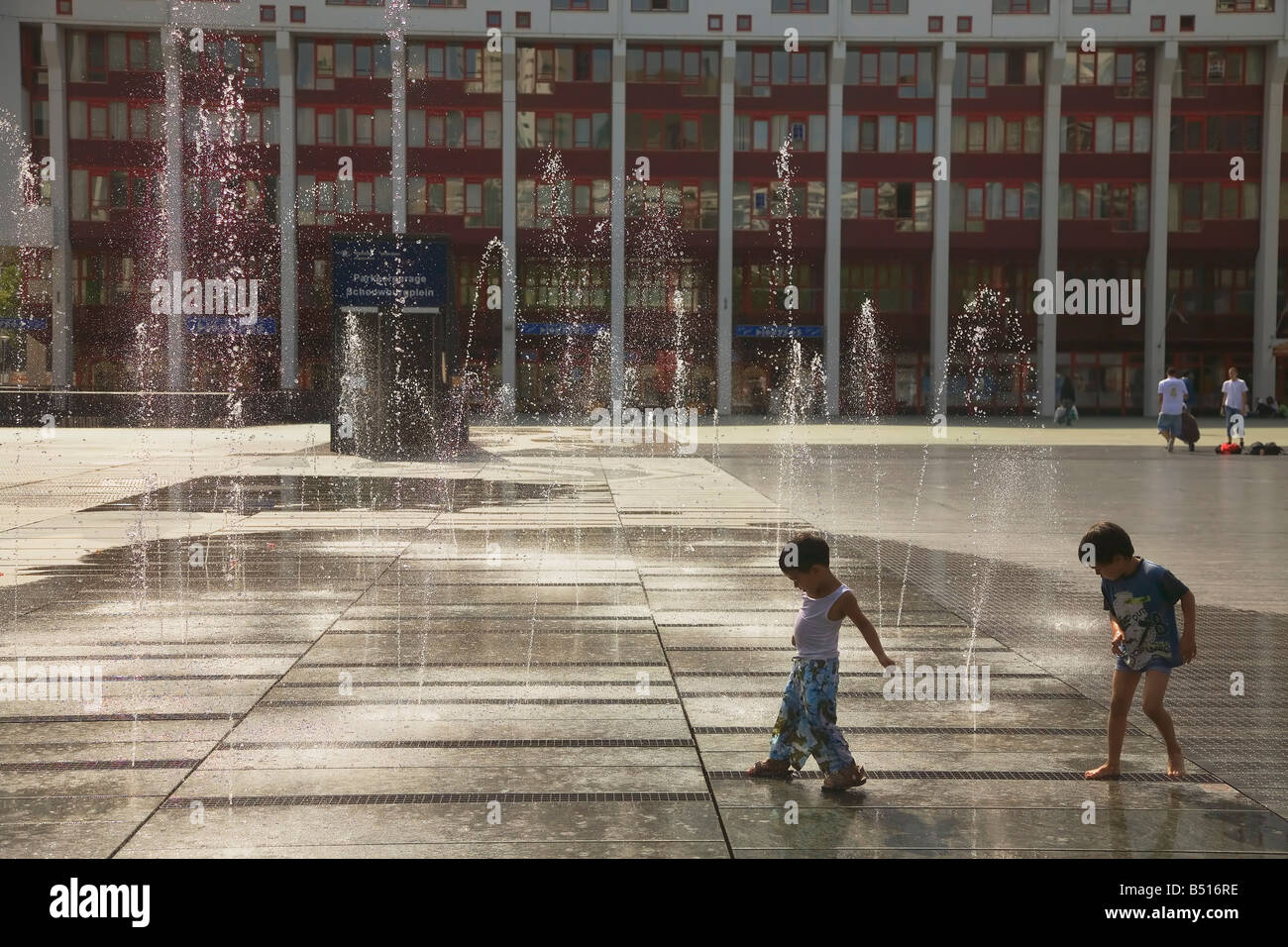 Due ragazzi poco divertirsi a giocare con l'acqua vicino al Rotterdam palazzo dei concerti Foto Stock