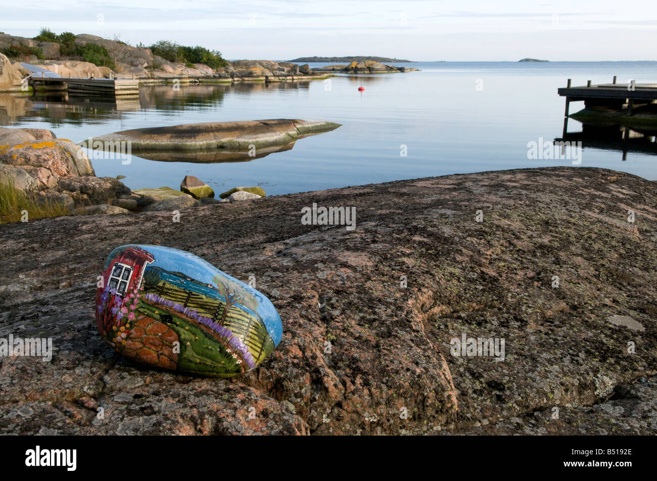 Dipinte a mano e pietra, accogliendo i visitatori, sulle rocce in calma baia, sull'isola di Västerö, Rödlöga nell'arcipelago di Stoccolma Foto Stock