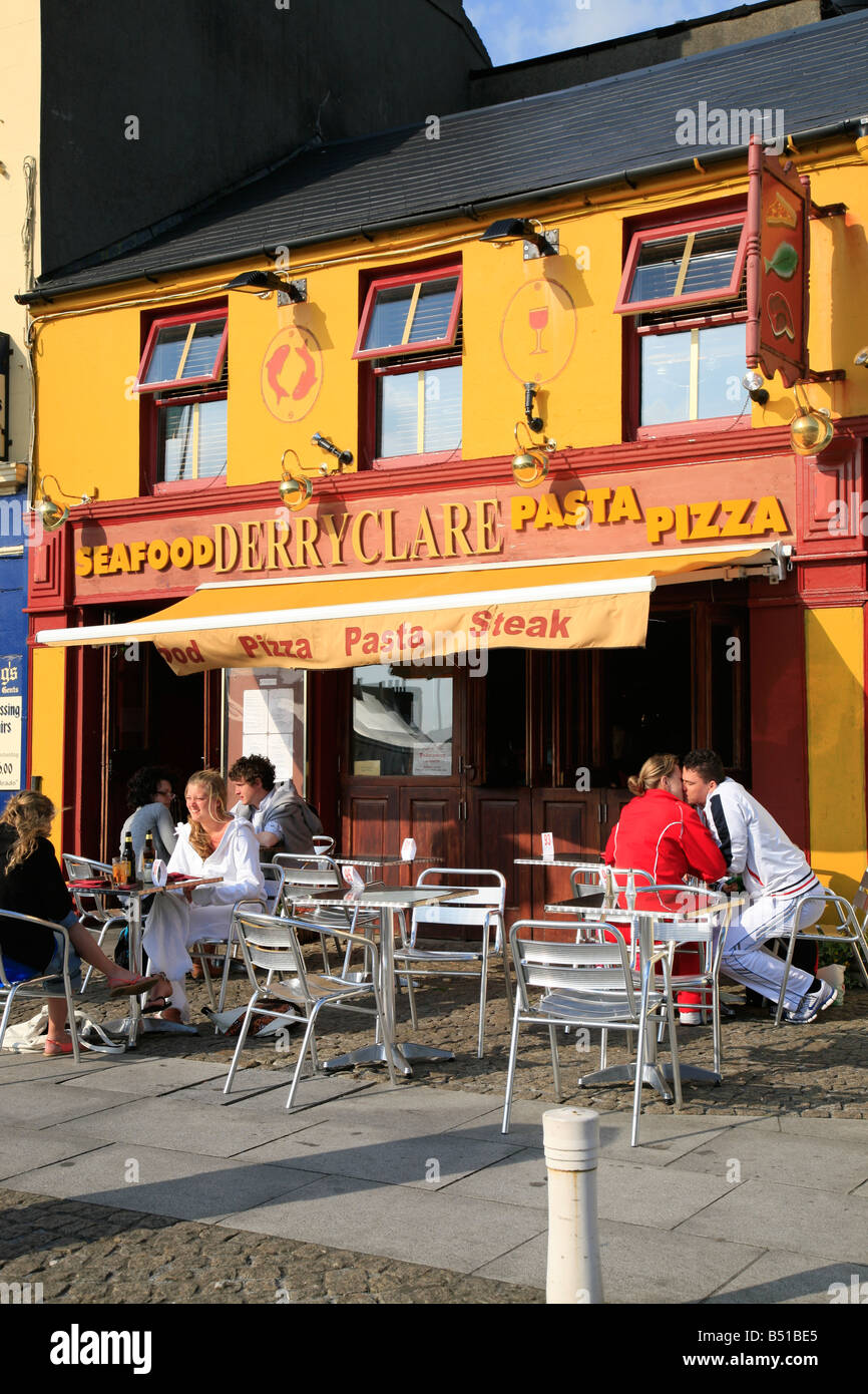 Persone sedersi davanti a un ristorante di pesce in Clifden, Irlanda Foto Stock
