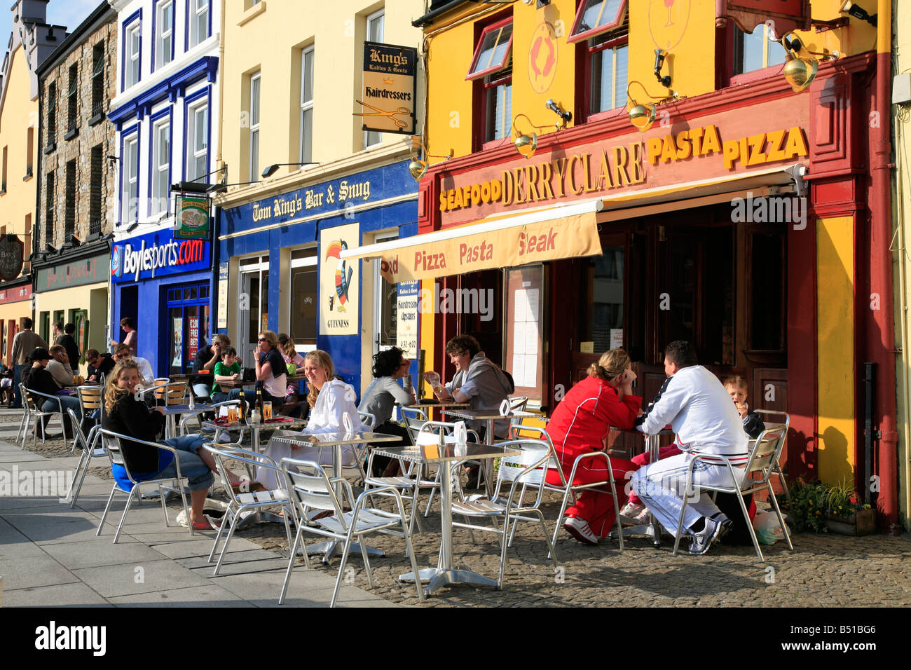 Persone sedersi davanti a un ristorante di pesce in Clifden, Irlanda Foto Stock