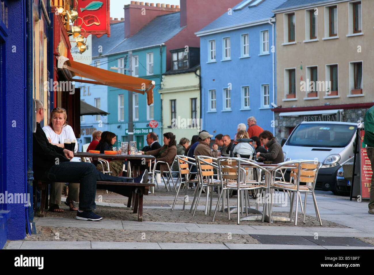 La gente seduta davanti a pub in Clifden, Irlanda Foto Stock