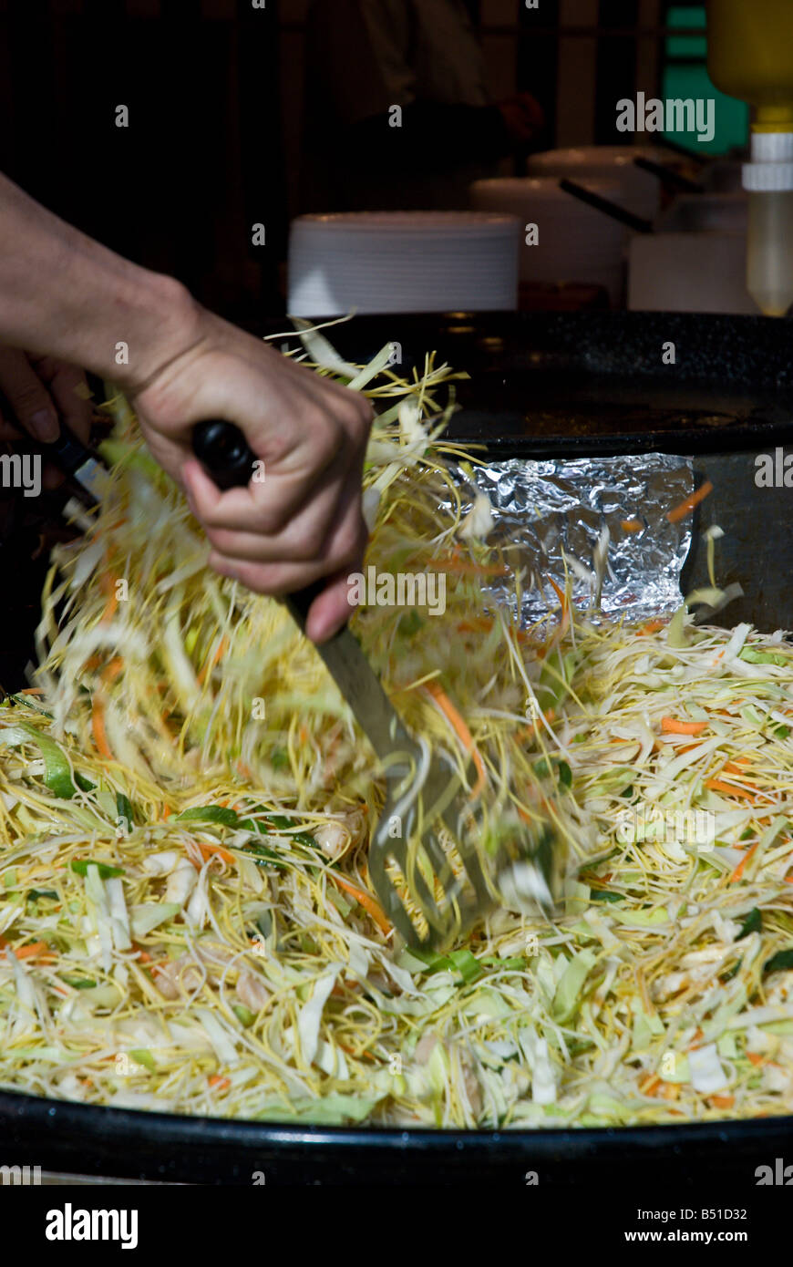 Cuocere lanci verdure orientali in aria Foto Stock