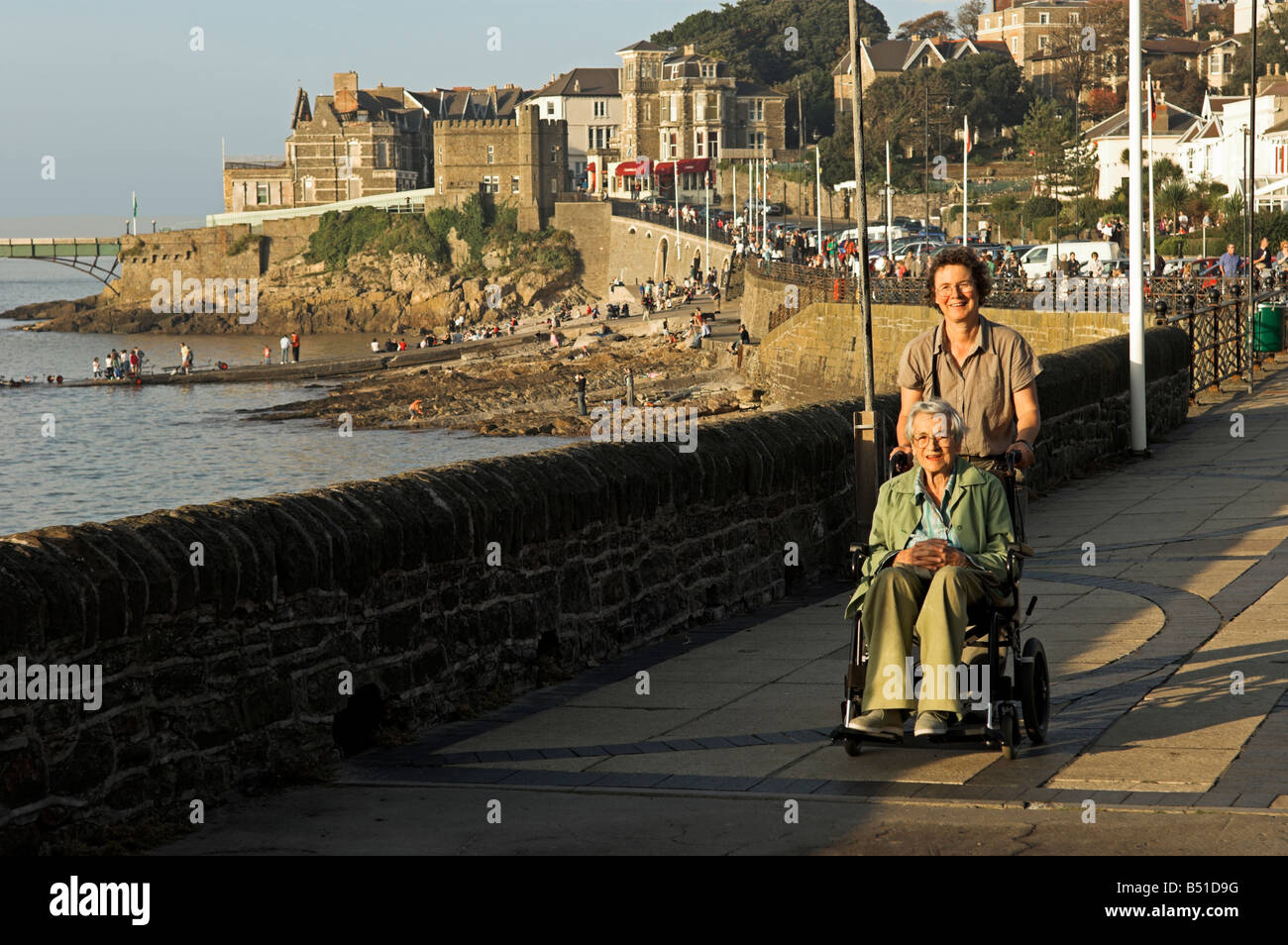 Medioevo donna con donna anziana in carrozzina da mare Clevedon Promenade North Somerset Foto Stock
