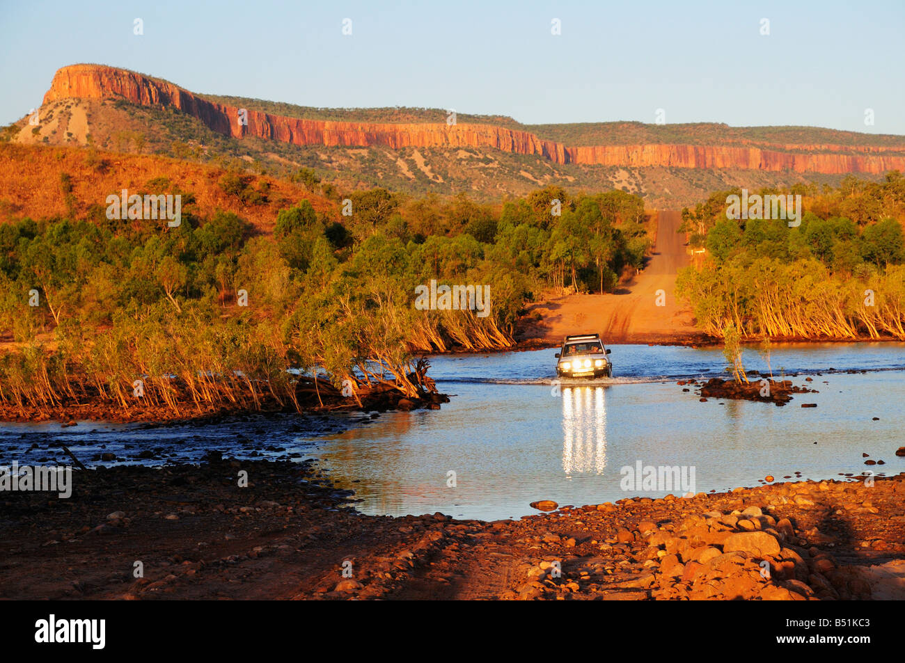 Veicolo Attraversamento fiume di Pentecoste con Cockburn varia in background, Gibb River Road, Kimberley, Australia occidentale Foto Stock