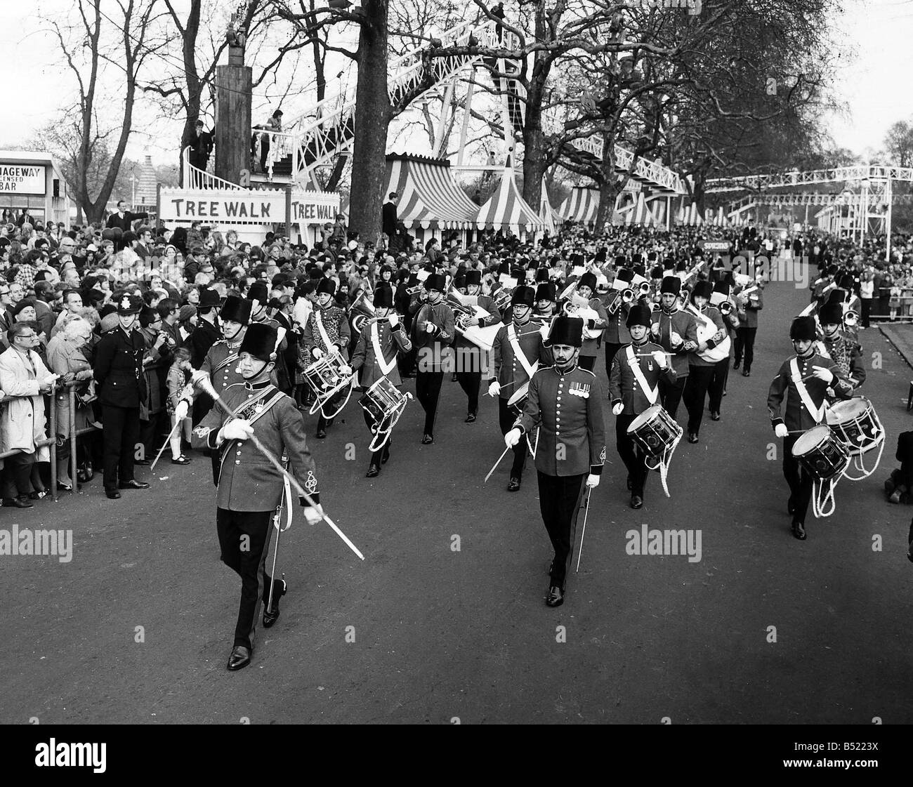 Una banda militare conduce la Battersea Easter Parade di 1971 come la folla si riuniscono per guardare Foto Stock