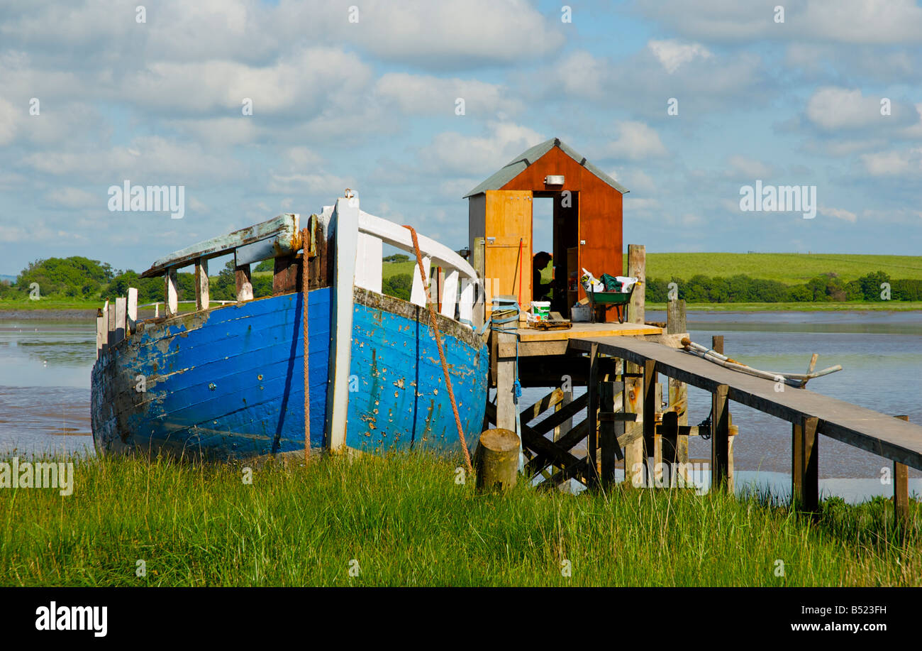 Barca e sgangherate molo sul Fiume Wyre a Skippool Creek, nei pressi di Fleetwood, nel Lancashire (Inghilterra, Regno Unito Foto Stock