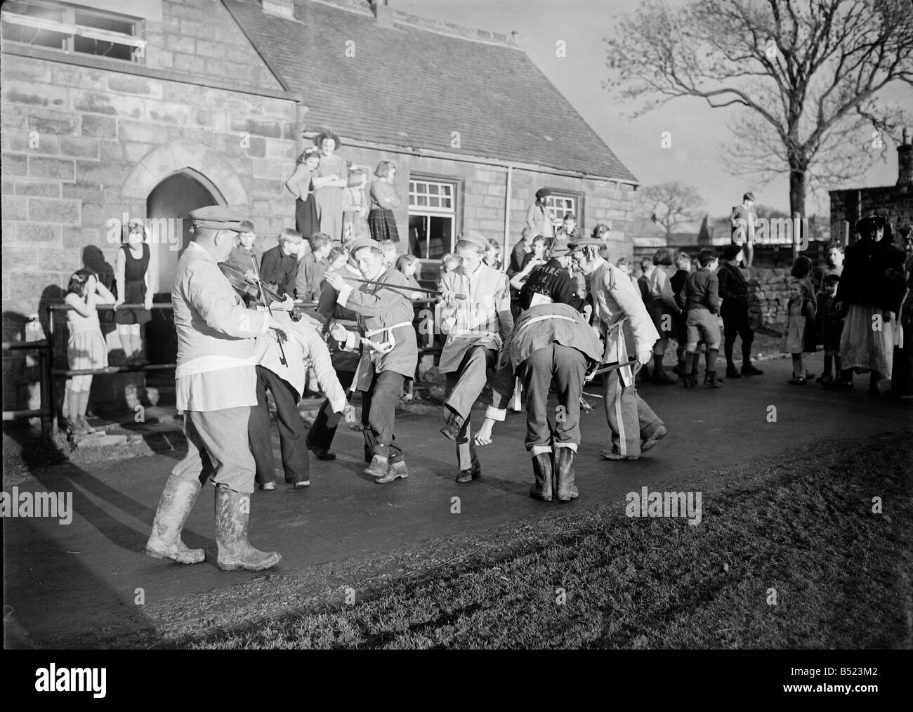 A Goathland slot aratro Yorkshire County dance team di eseguire la cerimonia antica di ballo prima di ogni casa di villaggio di Goatland, Yorks. L'Aratro a Goathland slot sono un raro esempio di quella che una volta era una diffusa tradizione rurale che ha riconosciuto l importanza dell'aratro e celebrata con la spada danza, musica e giochi popolari. Tradizioni simili sono noti per avere esisteva in altre parti dello Yorkshire, Lincolnshire, Derbyshire e Northumberland, dove erano conosciuti come "l'aratro Boys', 'giovenco Lads', 'Ploo brocche' aratro (Jack) e 'Fond o ingannare aratro'. Gennaio 1950 022214/1 Foto Stock