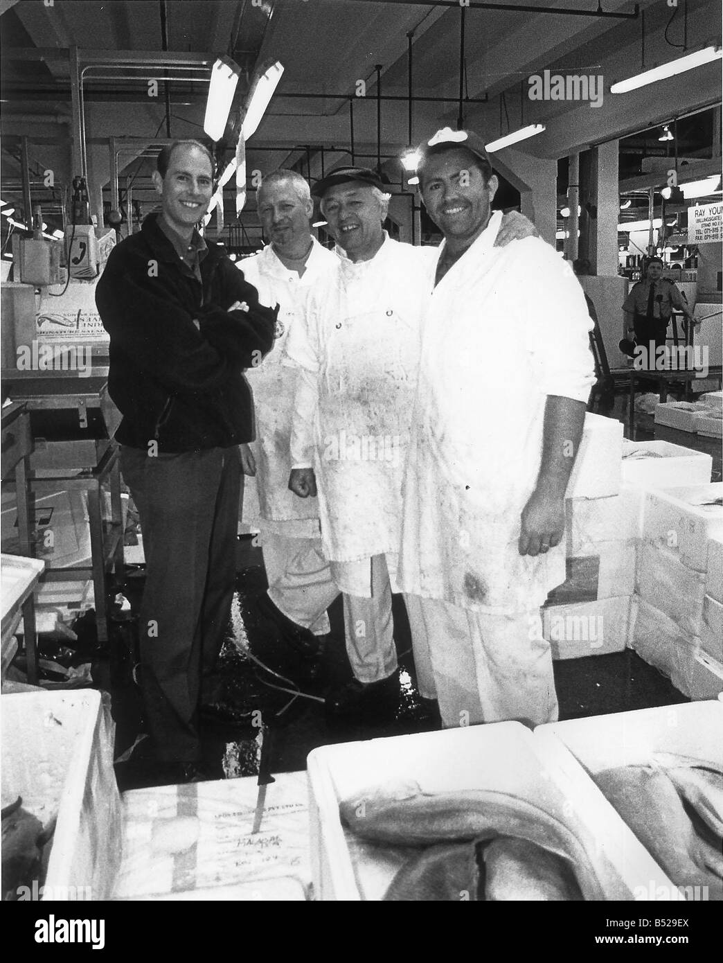 Prince Edward visite Bilingsgate Mercato del Pesce a film per la corona e il paese visto qui con tre uomini non identificati indossando tute bianche 28 Luglio 1999 Foto Stock