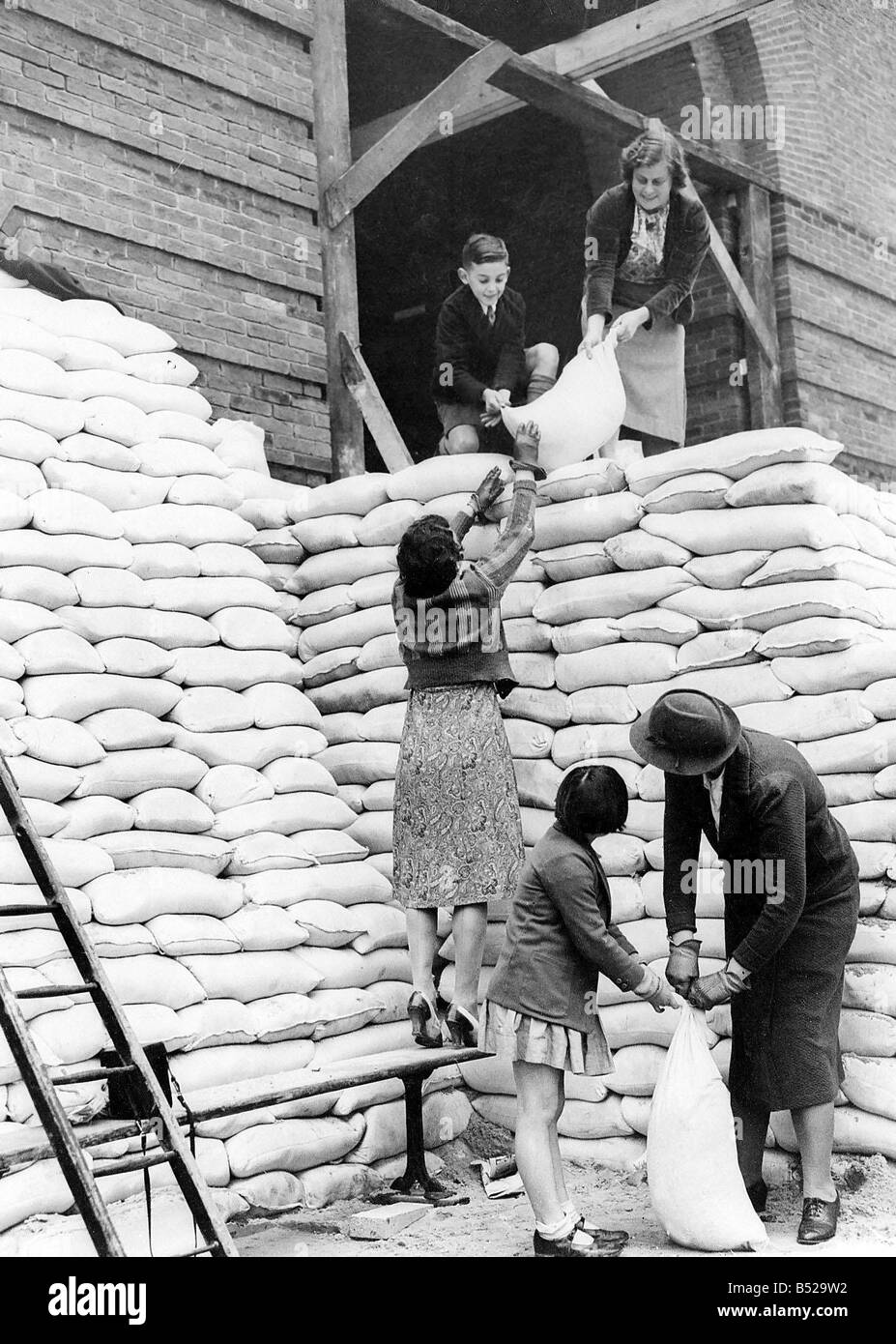 Le donne durante il WW2 1939 I genitori e i bambini aiutano a contrappeso l'ingresso principale a Manchester Scuola Grammer prima che la scuola è stata Foto Stock