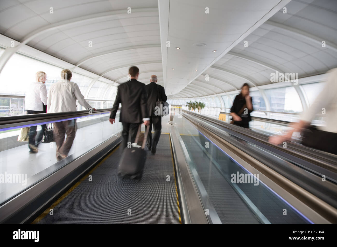 I passeggeri della compagnia aerea sul tapis roulants all uomo Aeroporto, Manchester, Inghilterra, Regno Unito Foto Stock