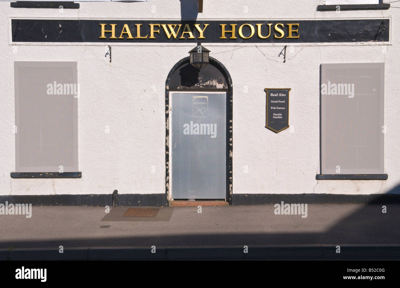 Halfway House pub windows e lo sportello anteriore intavolato con persiane in acciaio e stai cercando un nuovo inquilino UK Foto Stock