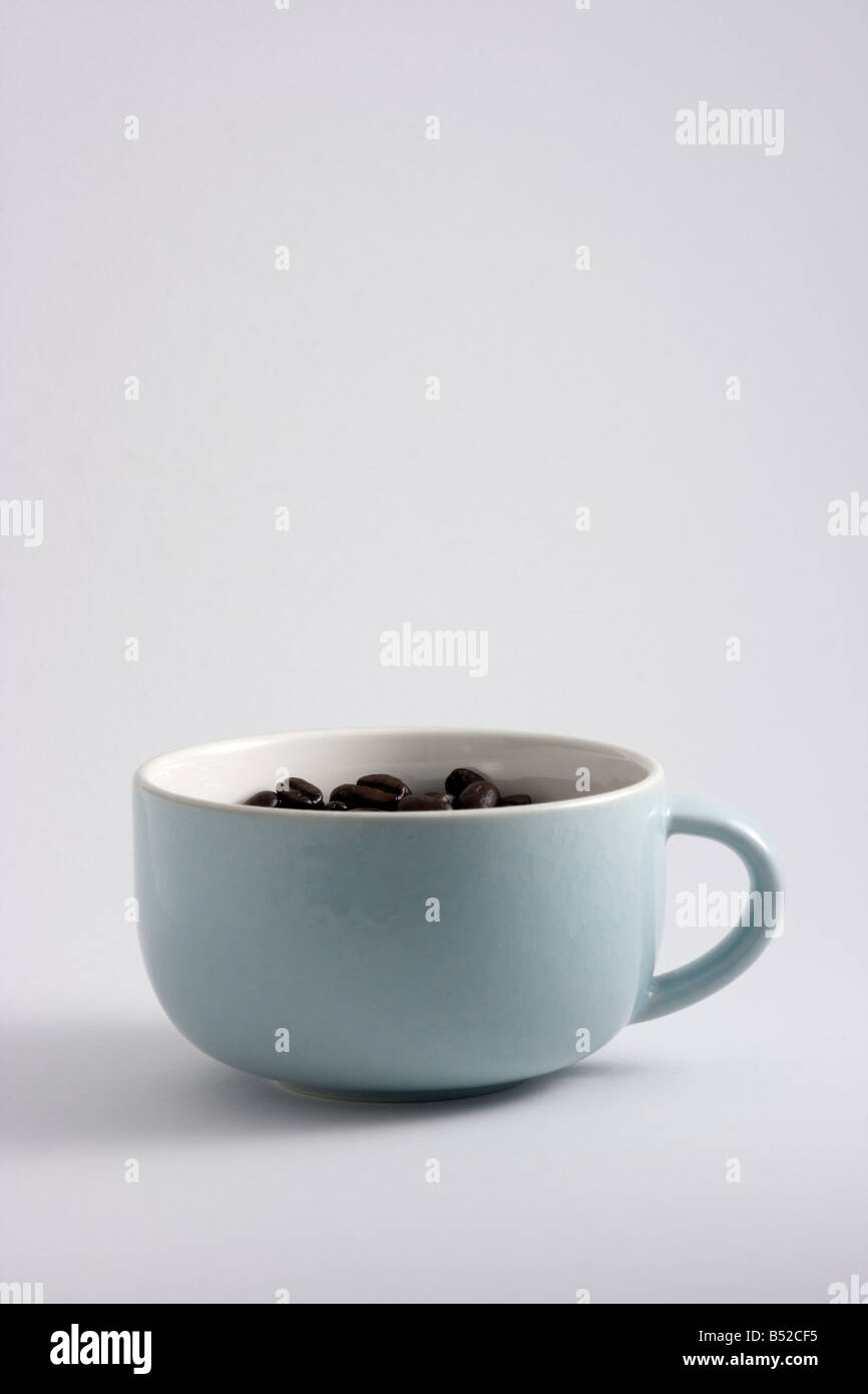 I chicchi di caffè girato in una tazza di caffè in una scatola luminosa Foto Stock