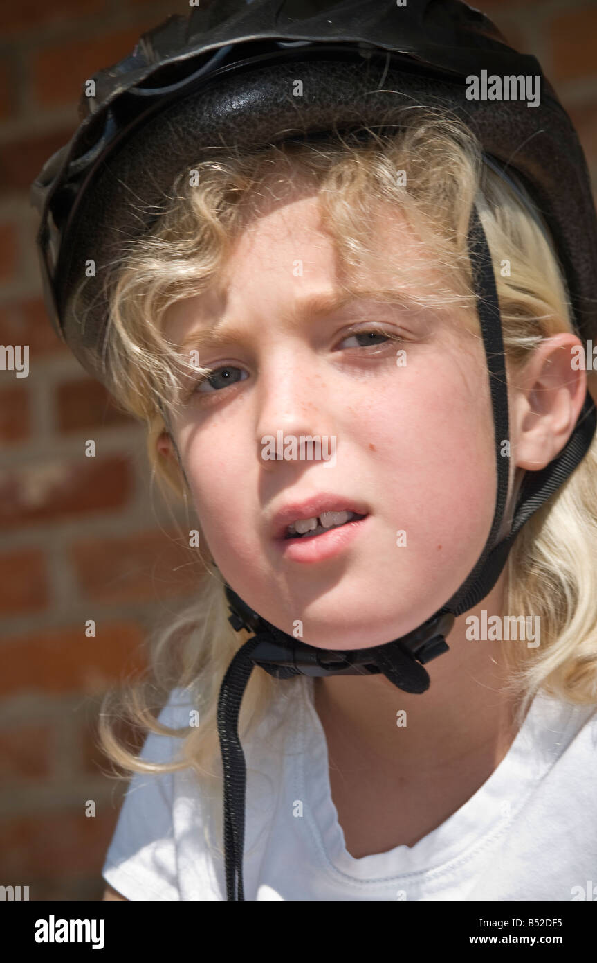 Giovane ragazza che indossa la sicurezza casco per bicicletta Foto Stock