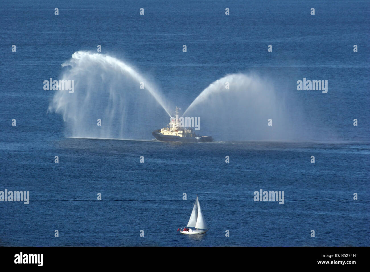 Fire Tug nel Firth of Clyde accogliente QE2 in Greenock per la sua ultima visita Foto Stock