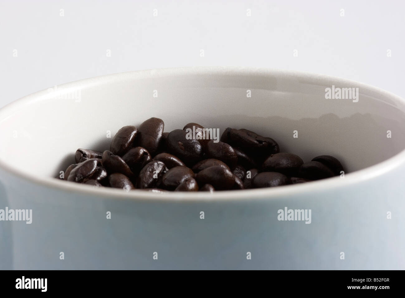I chicchi di caffè girato in una tazza di caffè in una scatola luminosa Foto Stock