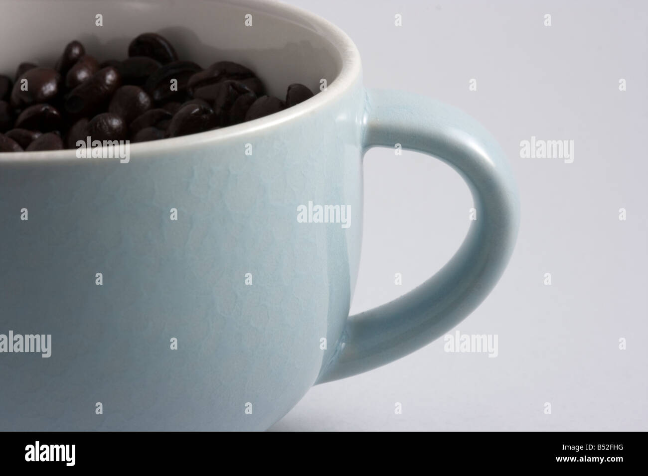 I chicchi di caffè girato in una tazza di caffè in una scatola luminosa Foto Stock