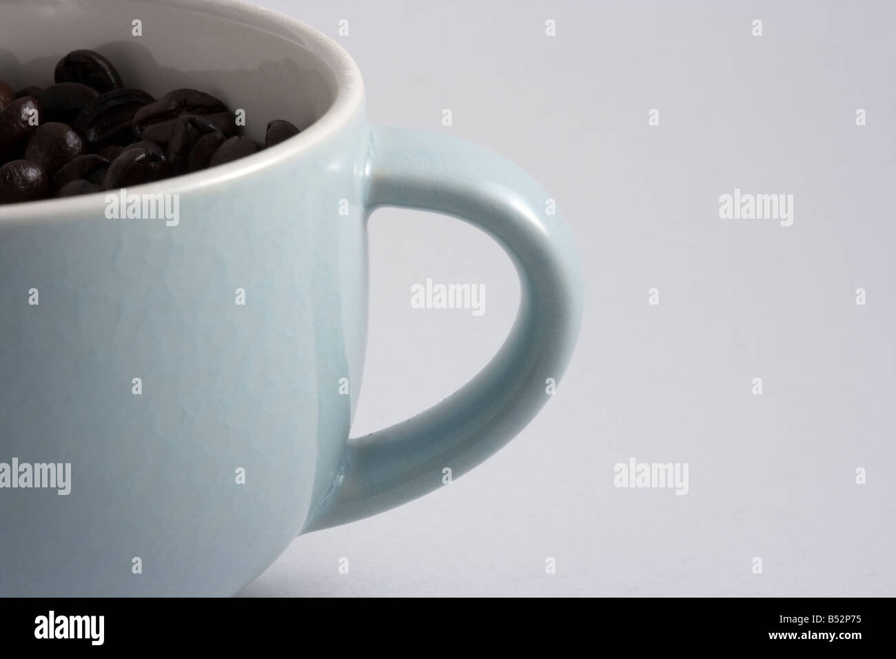 I chicchi di caffè girato in una tazza di caffè in una scatola luminosa Foto Stock