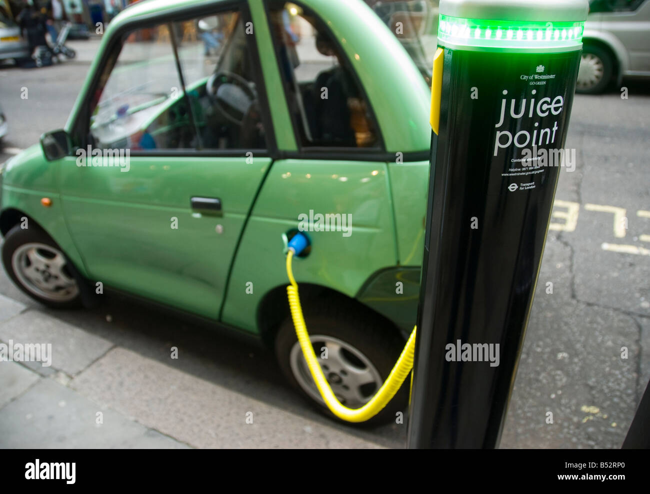 Una G Wiz auto elettrica carica da un City of Westminster succo punto nel centro di Londra Foto Stock