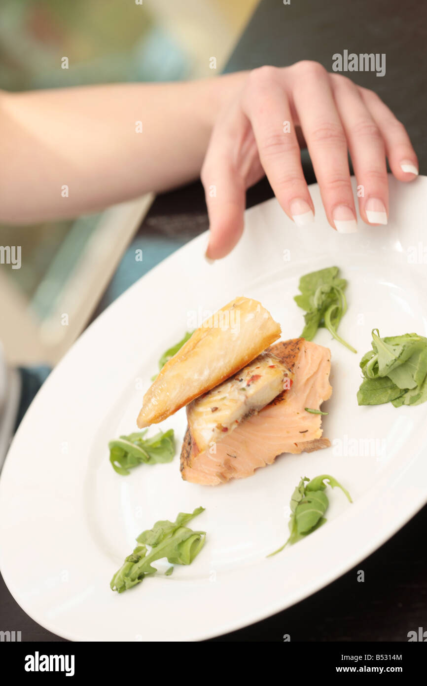 Giovane donna mangiare sgombro affumicato e salmone Modello rilasciato Foto Stock