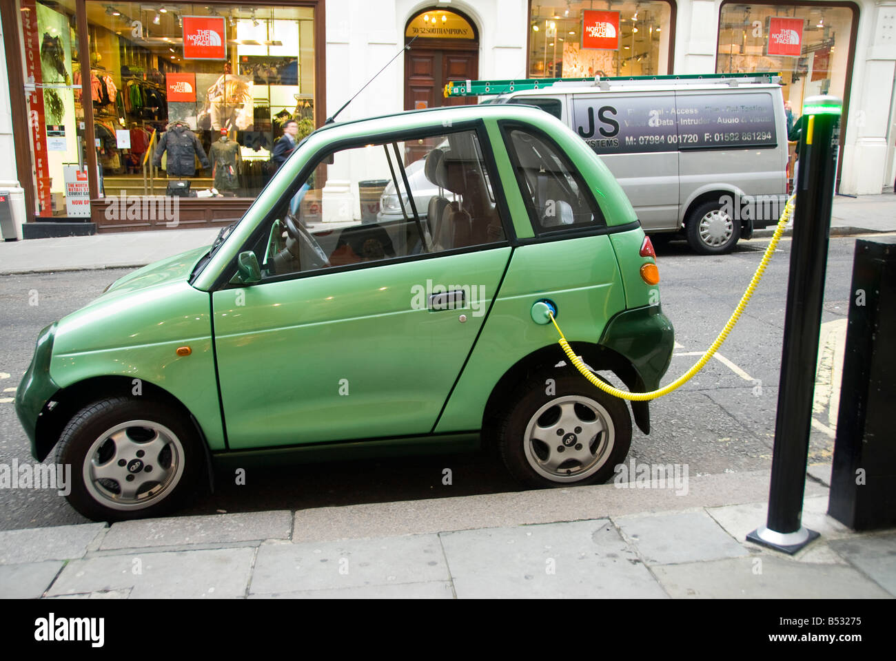 Una G Wiz auto elettrica carica da un City of Westminster succo punto nel centro di Londra Foto Stock
