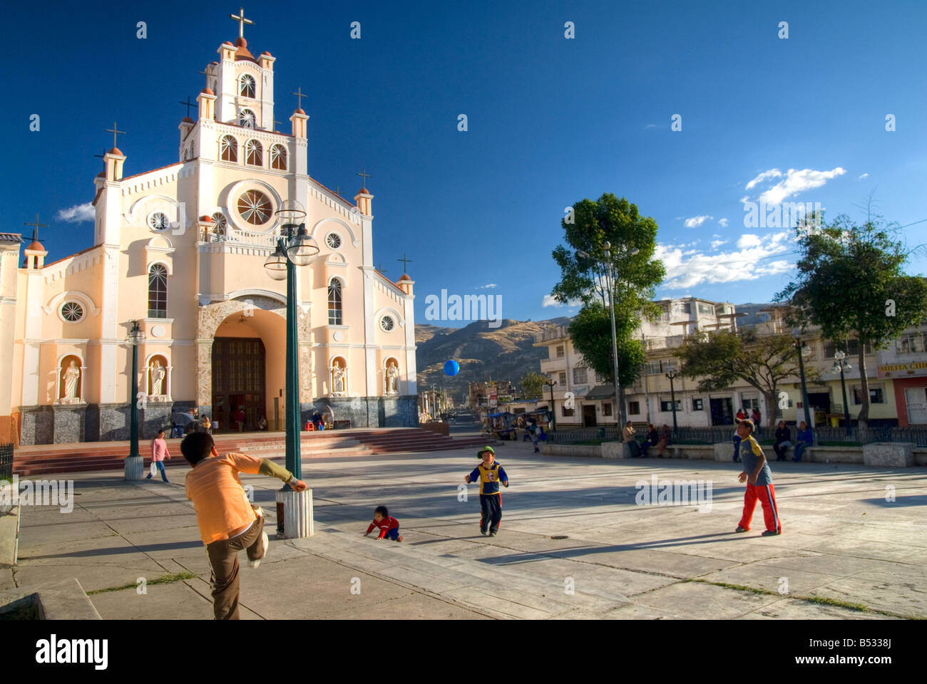 Bambini a giocare a calcio in piazza della chiesa Foto Stock