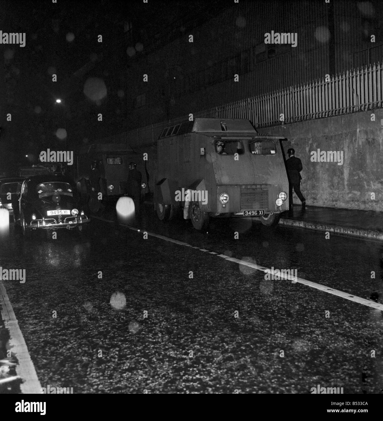 Irlanda del Nord Belfast Falls Road Agosto 1969. Poliziotto in piedi con la mitragliatrice; e benzina esplodere bombe round ca blindati Foto Stock