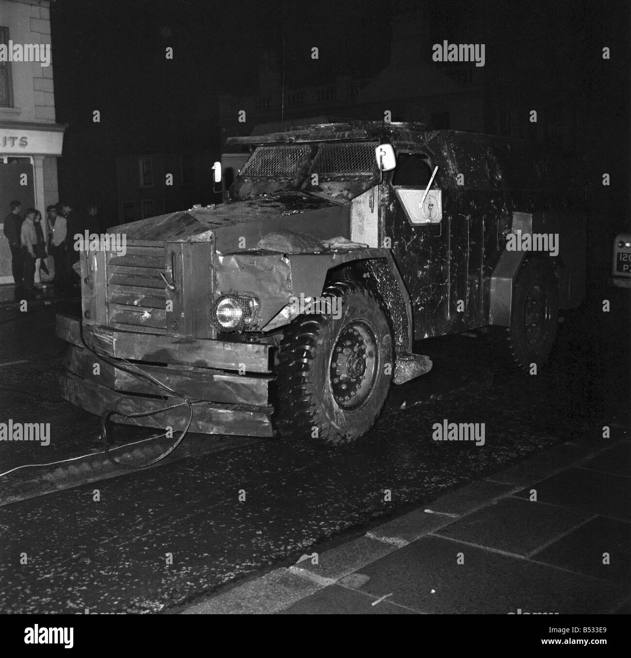 Irlanda del Nord Belfast Falls Road Agosto 1969. Poliziotto in piedi con la mitragliatrice; e benzina esplodere bombe round ca blindati Foto Stock