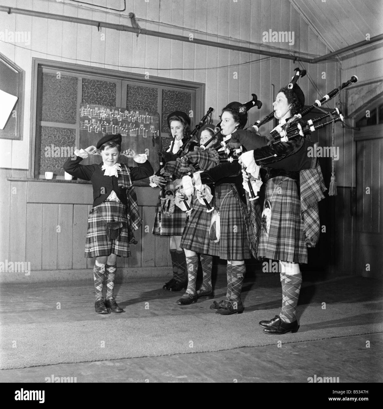 Donald Ross Woolwich Pipe Band la mascotte, con la sua finers nelle orecchie, non completamente appreicate il suono delle cornamuse. Aprile 1952 C1748 Foto Stock