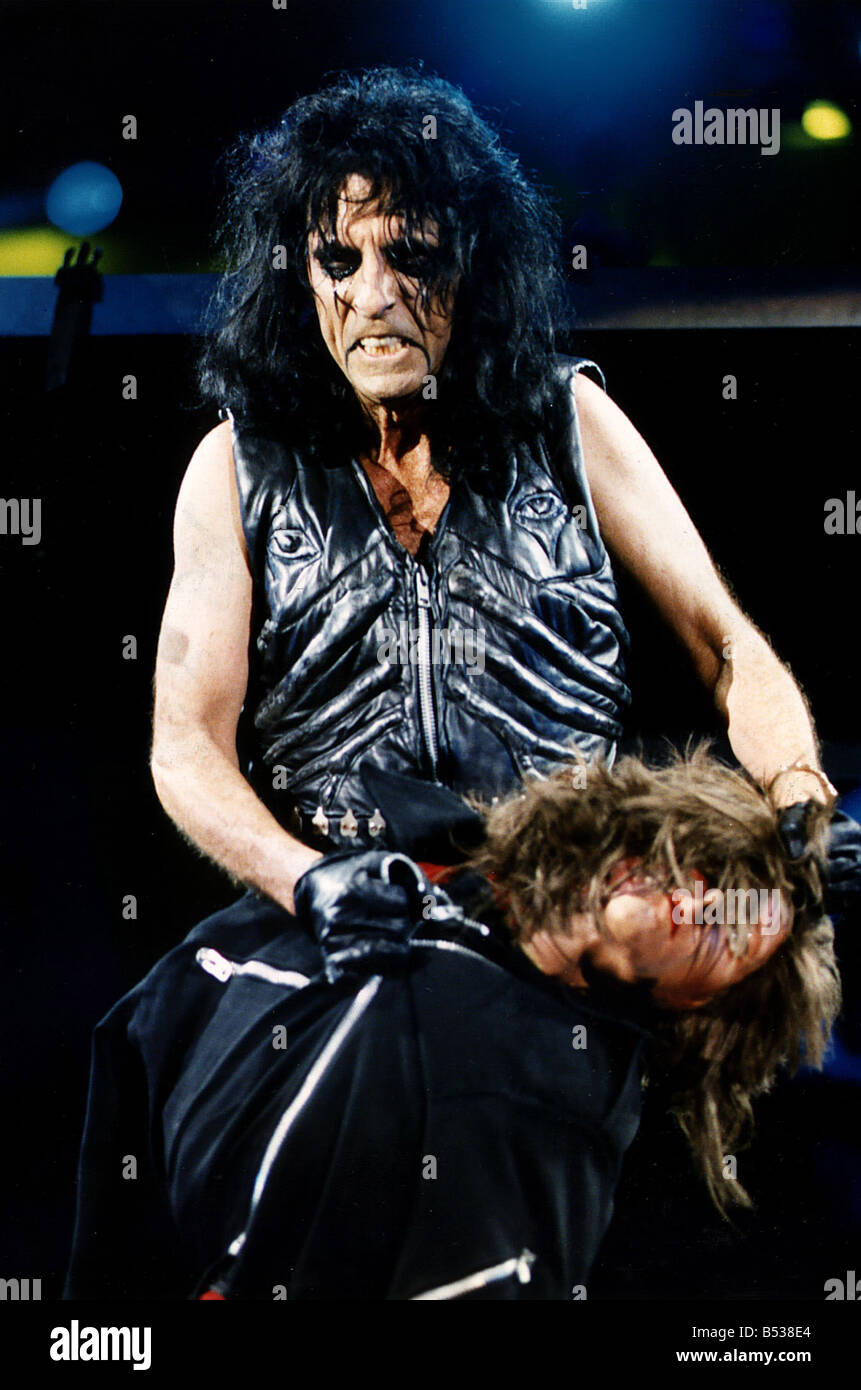 Alice Cooper il cantante Rock sul palco di grabbing manichino da collo Foto Stock