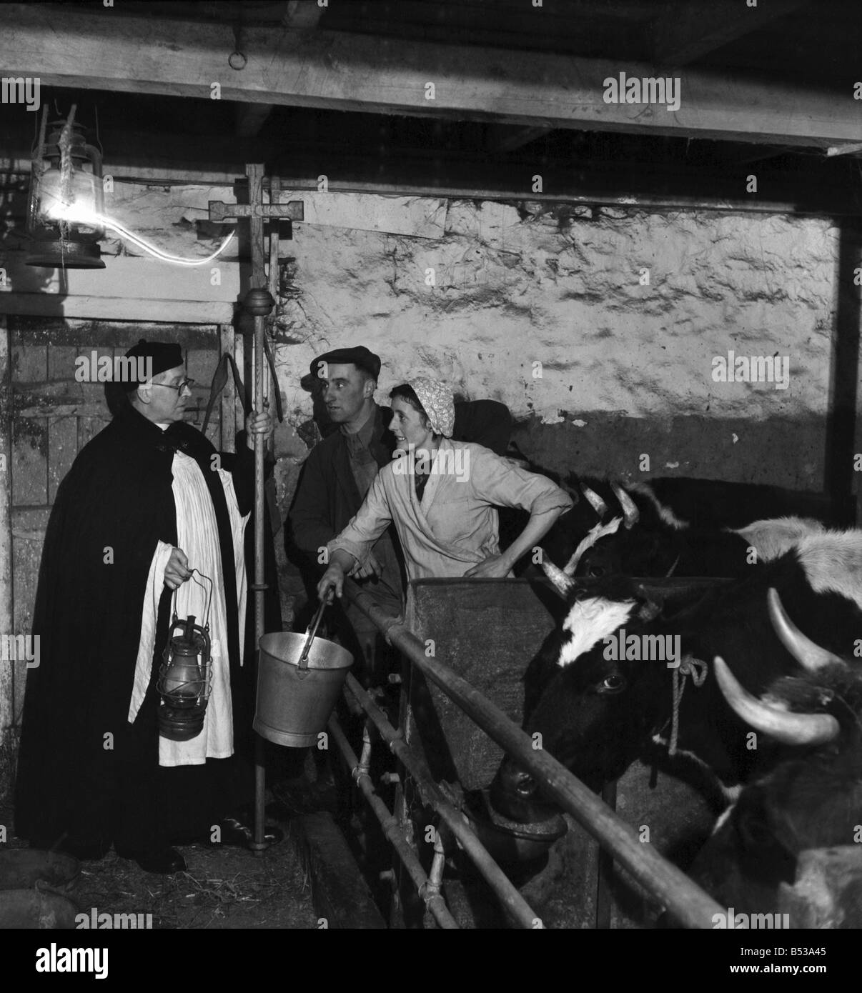 Il Reverendo Reid parla a Harry Richardson e sua moglie mentre si stanno preparando a letto le mucche giù per la notte. ;Dic. 195 Foto Stock