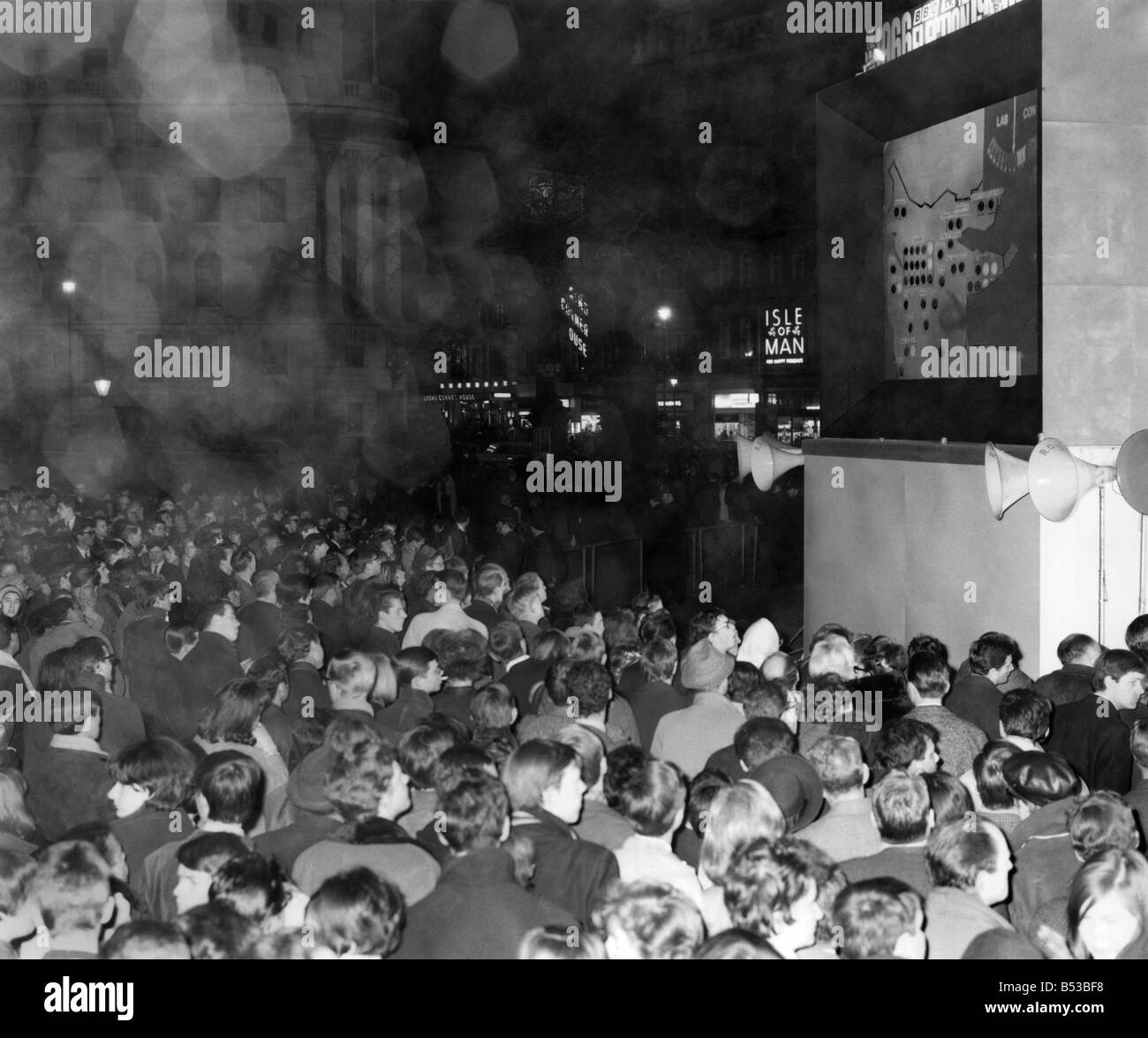 Elezioni generali 1966:00:00 Folle a Trafalgar Square a Londra guardando i risultati delle elezioni su uno schermo televisivo gigante. Mar. Foto Stock