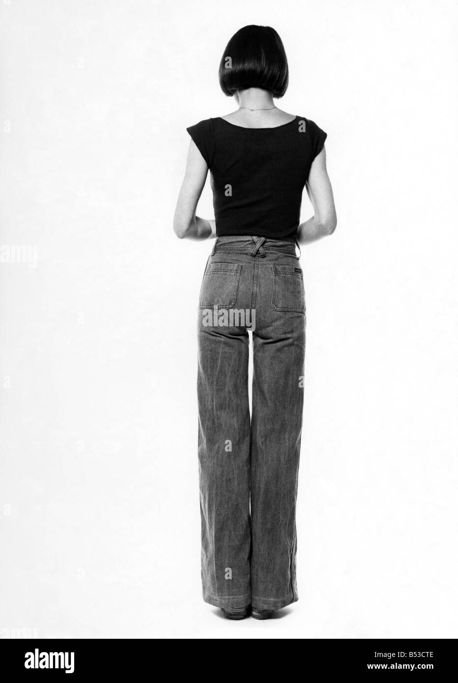 Moda - 1970s. &#13;&#10;Indietro della donna. Jeans e maglietta. &#13;&#10;Ottobre 1975 P017333 Foto Stock
