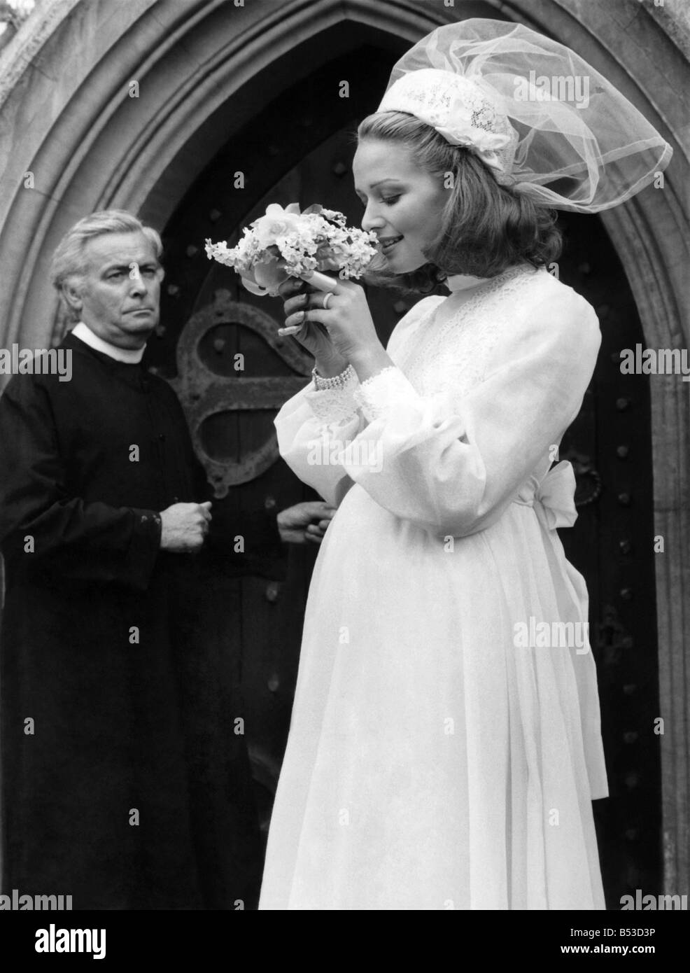 La moda degli anni settanta: ecco che arriva La sposa... cercando si gonfiano. Le attuali tendenze nella moda nuziale sembra essere il catering per la sposa in gravidanza. Presso la maggior parte delle recenti sfilate abiti da sposa descritto come linea di impero, o semplicemente camici, sono stati inclusi. La caratteristica principale di entrambi questi stili è la fluente mantello che cade libero da un alto-aumento corpetto. Molto può essere nascosta al di sotto di una inesistente la cintura e... Non è naturalmente di essere incinta per guardare splendida in uno di questi abiti Foto Stock