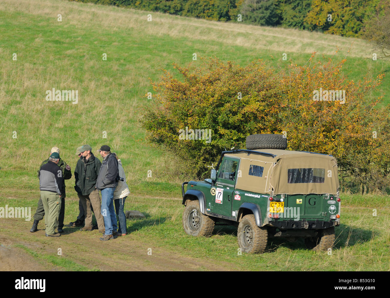 Land Rover equipaggi in piedi accanto a un Difensore 90 nella zona collinare Weserbergland. Foto Stock