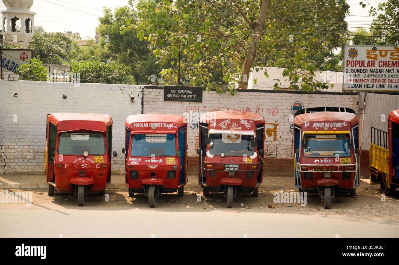 Una fila di rosso " popolare " Farmacia tuc tucs in attesa di andare per le consegne, Delhi, India Foto Stock