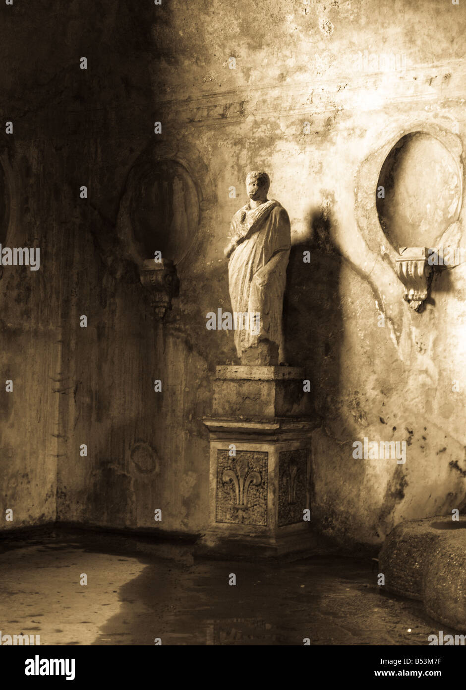 Antica statua romana in piedi in una caverna scura Foto Stock
