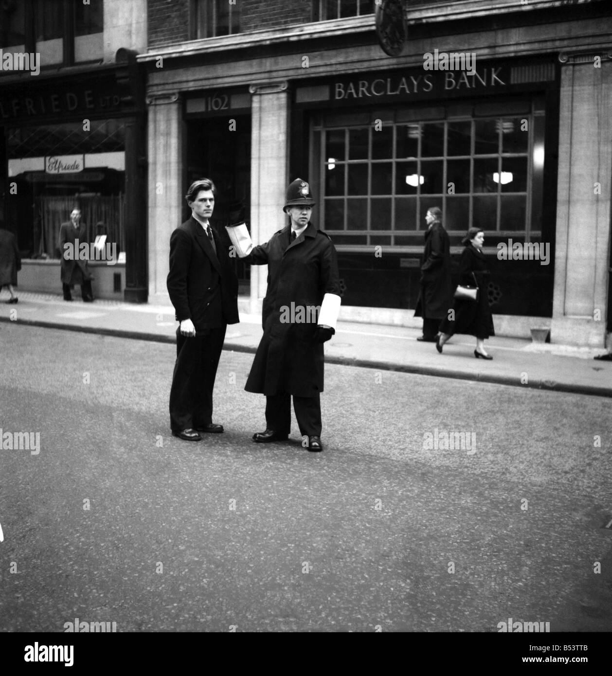 Metropolition Polizia, un uniforme constable è richiesto di direzione da parte di un membro del pubblico a Londra. Febbraio 1953 D970-002 Foto Stock