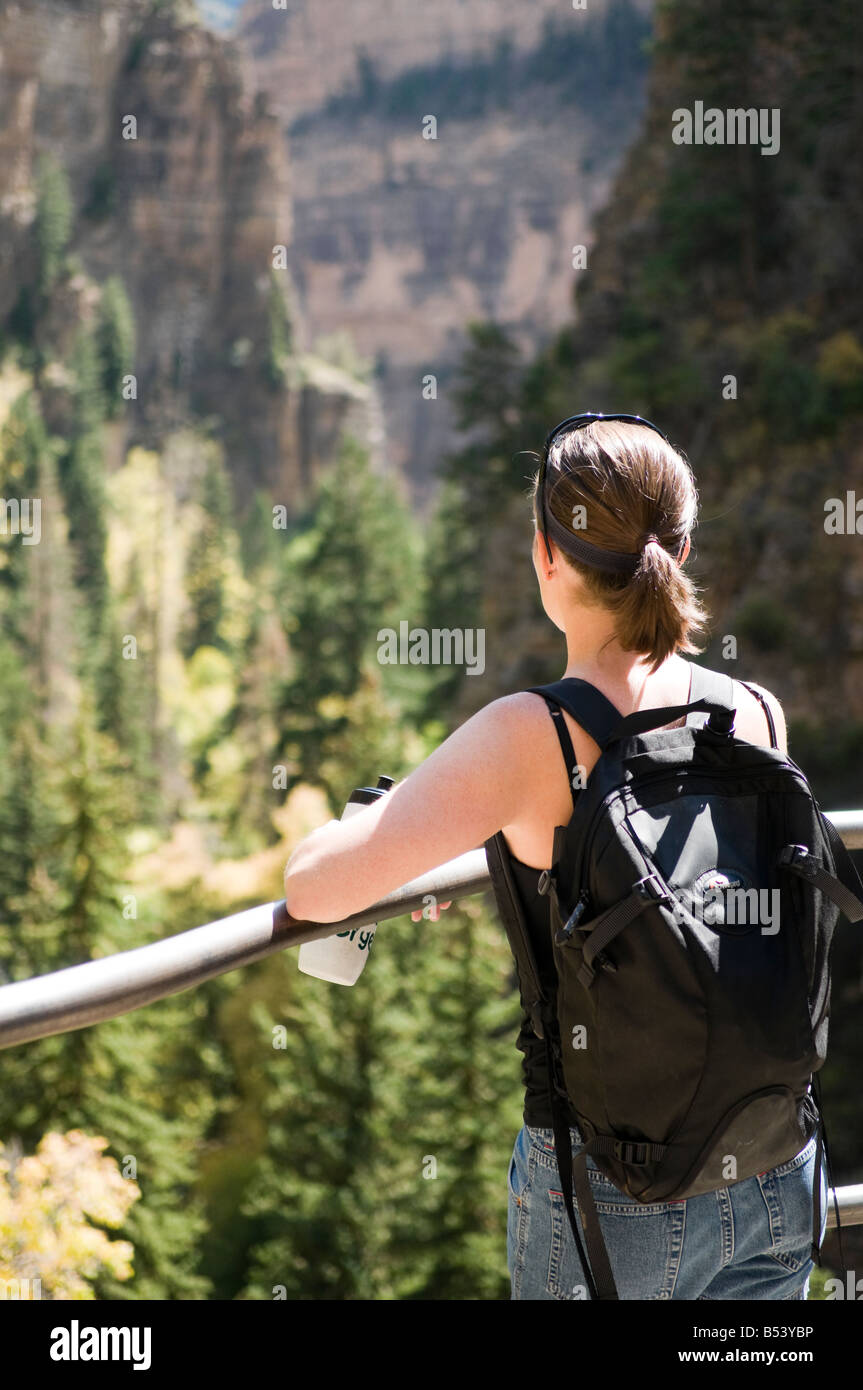 Giovane donna che si affaccia sulla valle durante una escursione in montagna Foto Stock