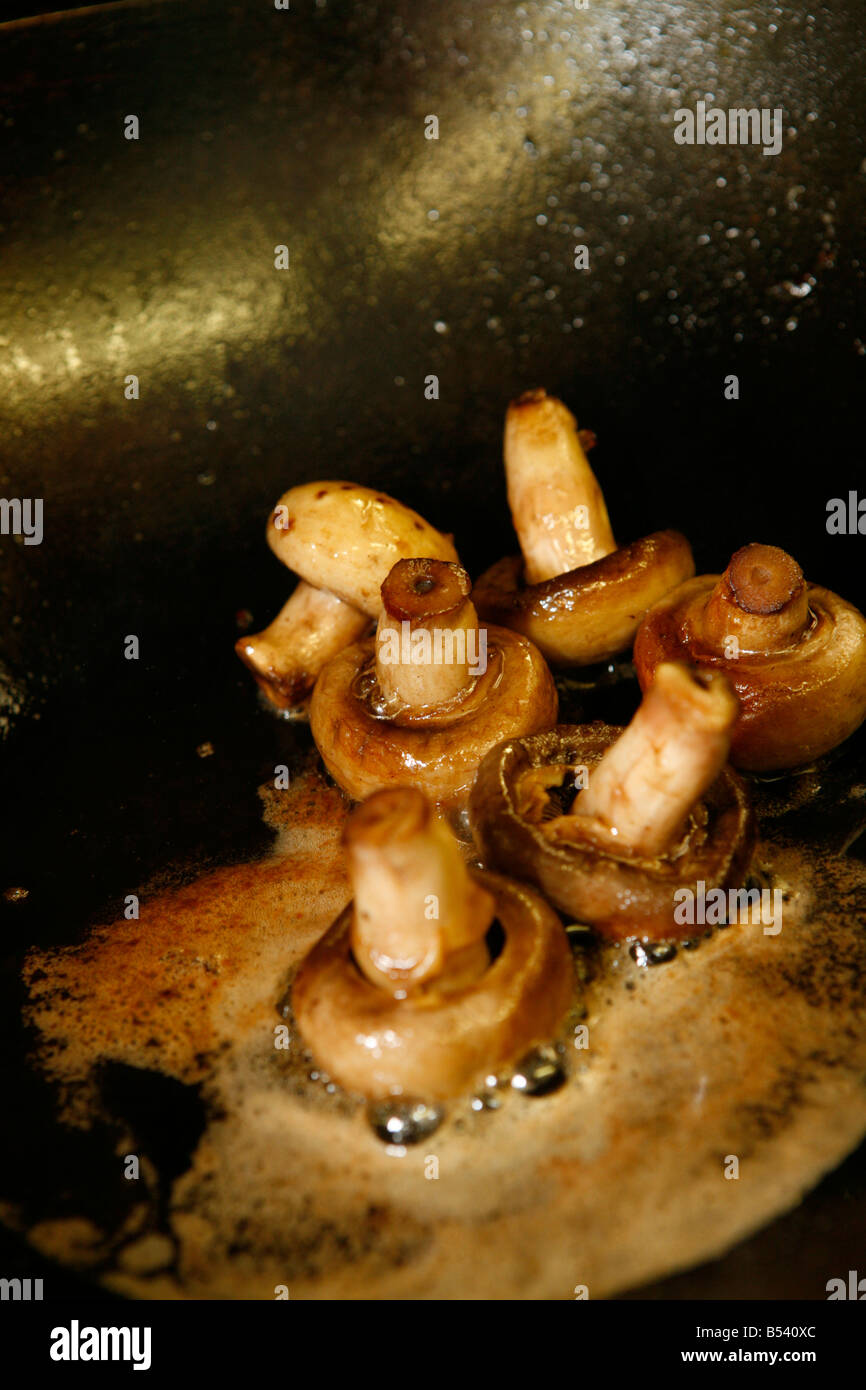 Funghi prataioli fritti in padella Foto Stock