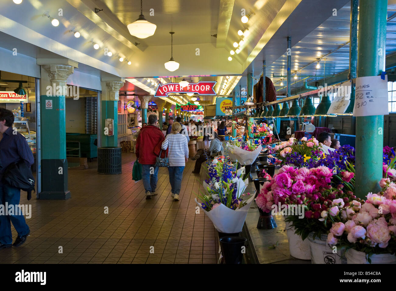 Una coppia di negozi passerà di braccio in braccio attraverso il Pike Place Market nel centro di Seattle, Washington Foto Stock