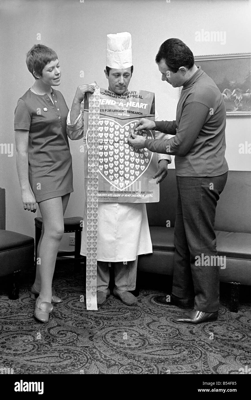 Umorismo. L uomo e la donna a copertura di un uomo in un Chef's uniforme nei cuori di plastica. Novembre 1969 Z11230 Foto Stock