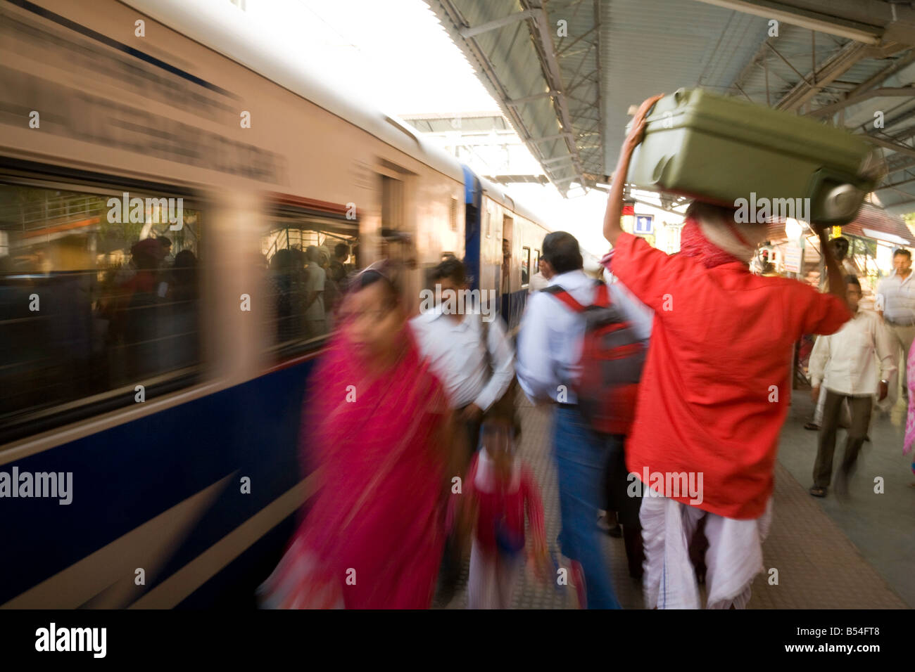 Un portiere porta borse come il treno arriva in stazione, India Sawai Madhopur stazione, Rajasthan, India Foto Stock