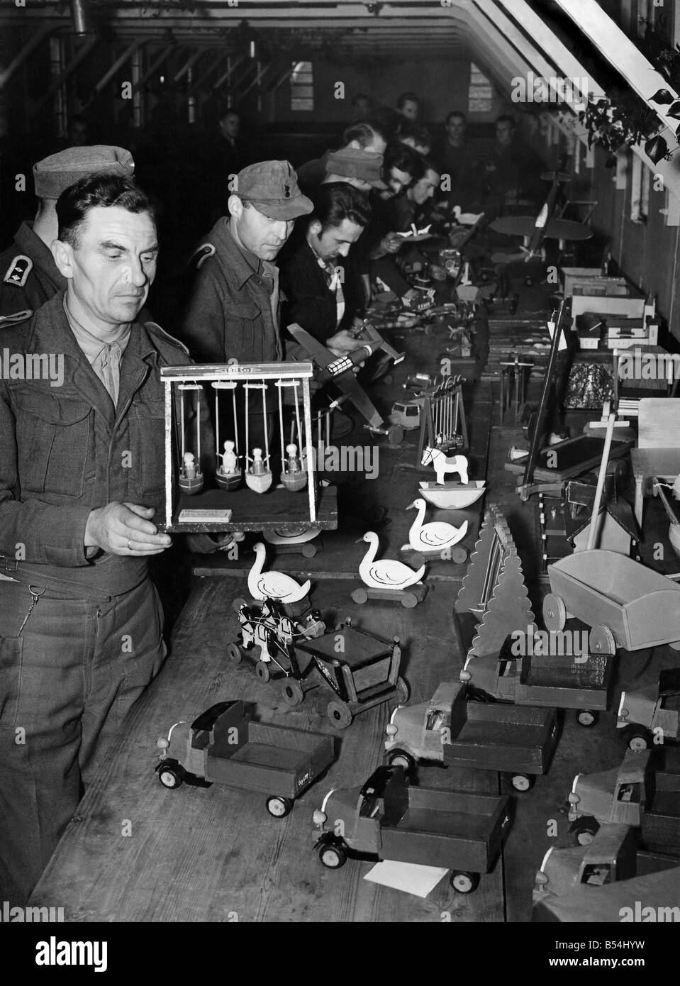 I soldati tedeschi in un accampamento di PRIGIONIERO DI GUERRA nel sud-ovest della Cornovaglia stanno rendendo incantevoli giocattoli per la distribuzione gratuita a tempo di Natale per i bambini orfani dei militari e i bambini i cui padri sono stati disabilitati in guerra. Realizzato da lattine vuote, legno di scarto e chiodi, i tedeschi volontariamente sul lavoro toymaking nel loro tempo libero, utilizzando il crudest di strumenti. ;Novembre 1945 ;P011630 Foto Stock