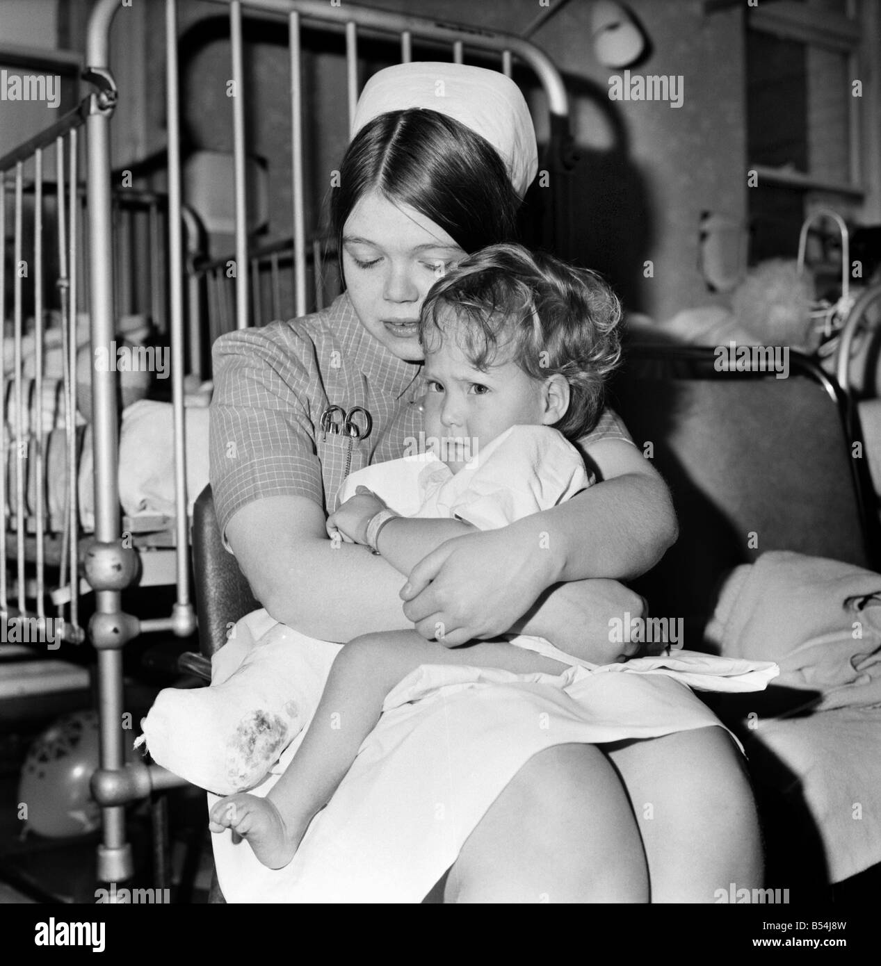 I bambini di stand Hall Hospital soddisfare carattere da Alice nel paese delle meraviglie: infermiera Bridie Connoly e baby. Dicembre 1969 Z11823-020 Foto Stock