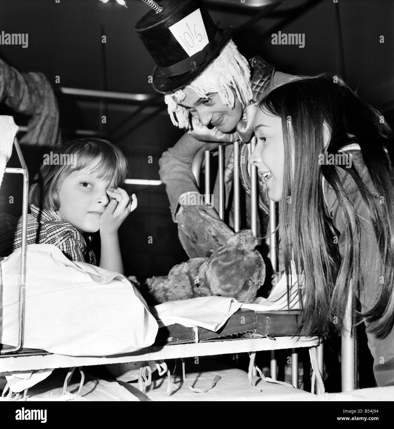 I bambini di stand Hall Hospital soddisfare carattere da Alice nel paese delle meraviglie: Janet Harrop,5, guardò fino dalla sua camera da letto e non vi è stato il Mad Hatter e Alice. Dicembre 1969 Z11823-022 Foto Stock