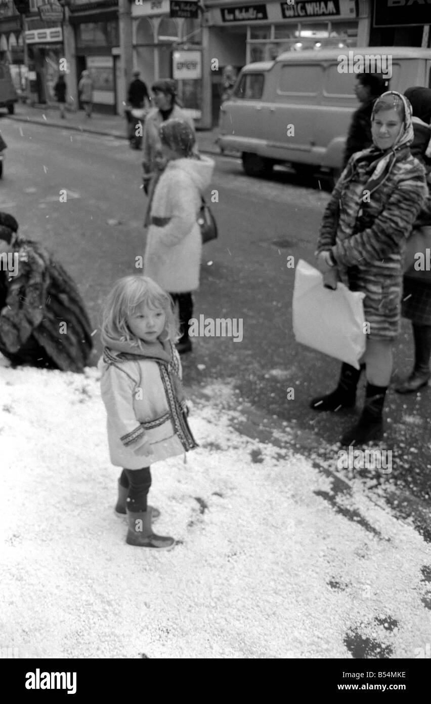 Scene di festa. In South Molton Street, Mayfair, stava nevicando ma era solo neve in plastica che era caduta. Il cantante Clodagh Rogers era presente con il padre e la Madre di Natale, per aprire la strada del display di Natale di luci. Sacha luminoso (2 1/2) sorge confusi sulla neve di plastica mentre il resto della strada è arida. Dicembre 1969 Z11515 Foto Stock