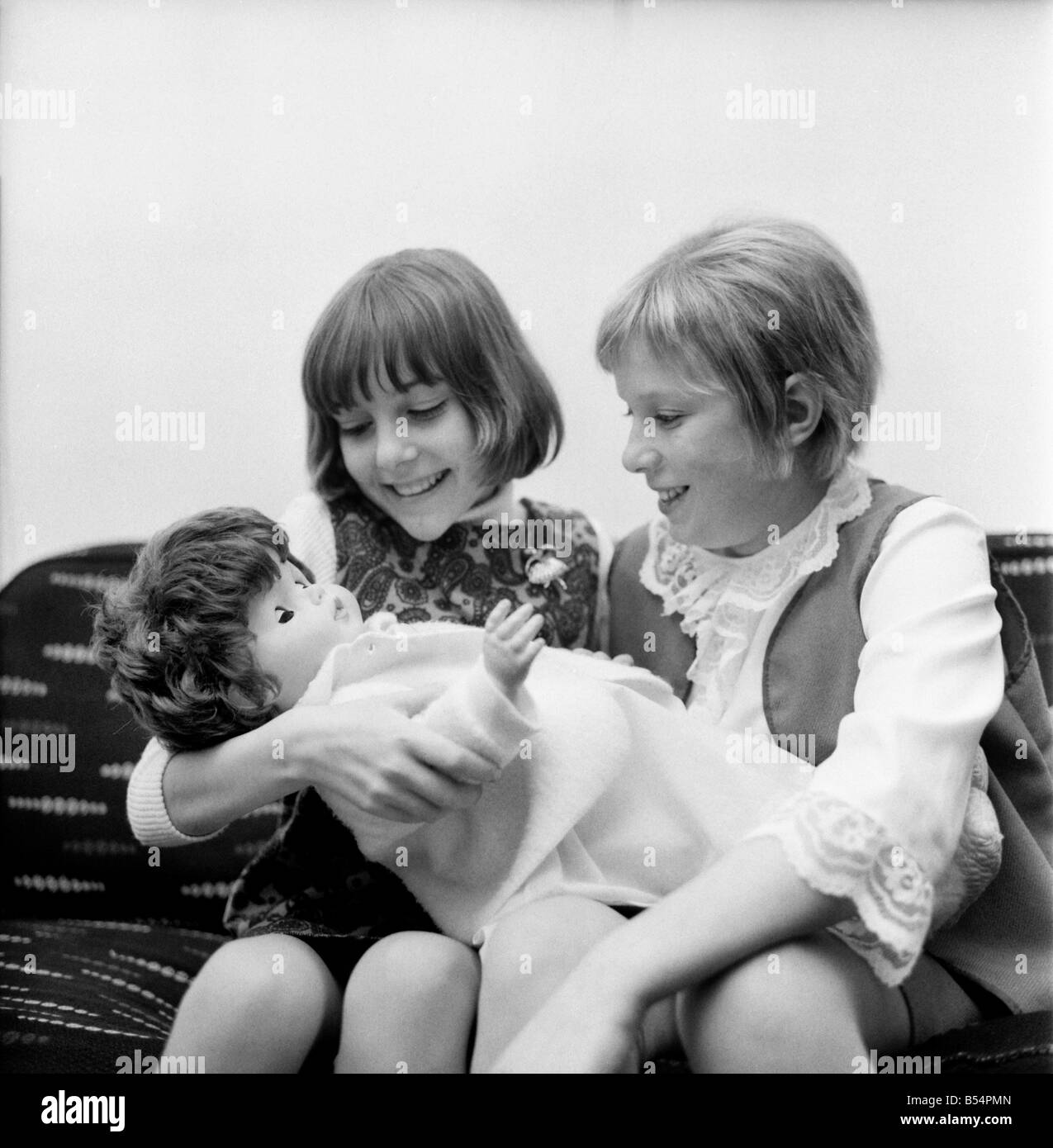 I bambini giocando: Ragazze: Hilary legno (sinistra) e Melanie Smith (sia di età compresa tra i 12) con la nuova bambola che sarà tenuto a loro Adop Foto Stock